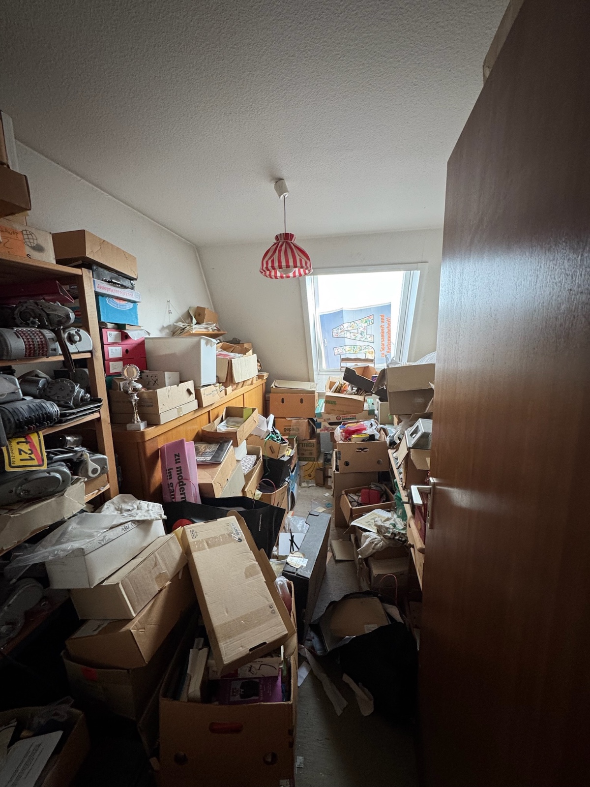 Messiwohnung vor der Entrümpelung: Zimmer voller Kartons, Kisten und Hausrat